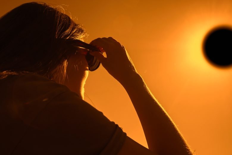 Woman wearing protective eyewear to watch total solar eclipse