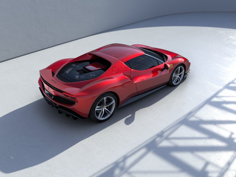 An red Ferrari up against a grey background.