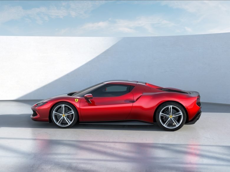 A red Ferarri up against a grey background