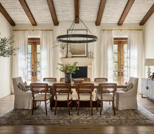 A view of the dining room with exposed beams and large windows.