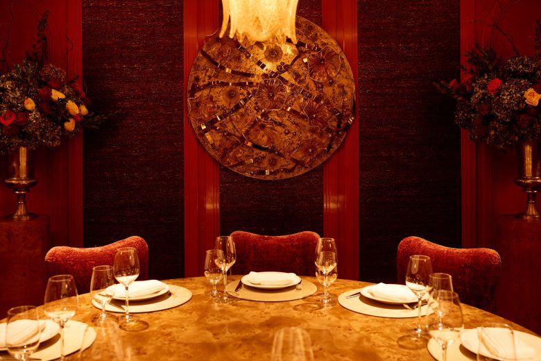A dimly-lit dining room with velvet seating.