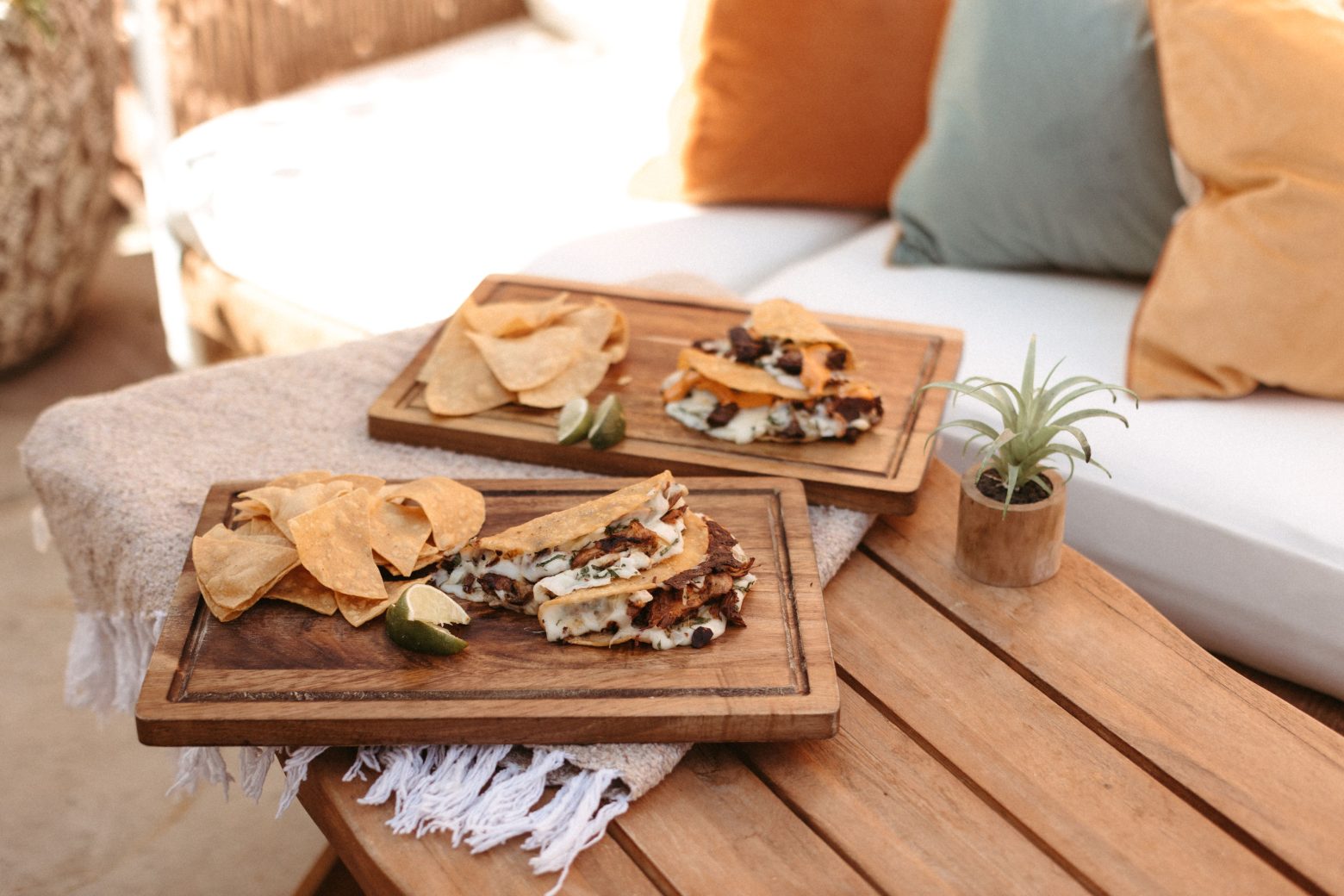 Tacos and tortilla chips on a wooden cutting board.