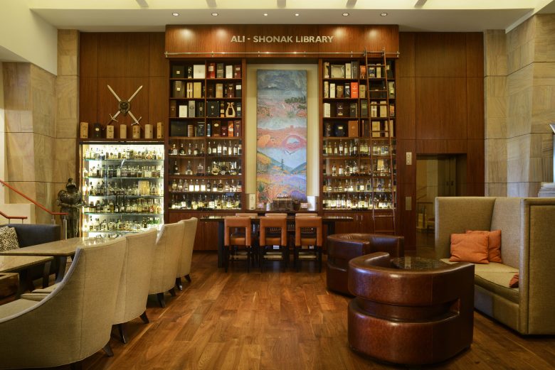 The inside of the Scotch Library with dark wood tones and plush seating.